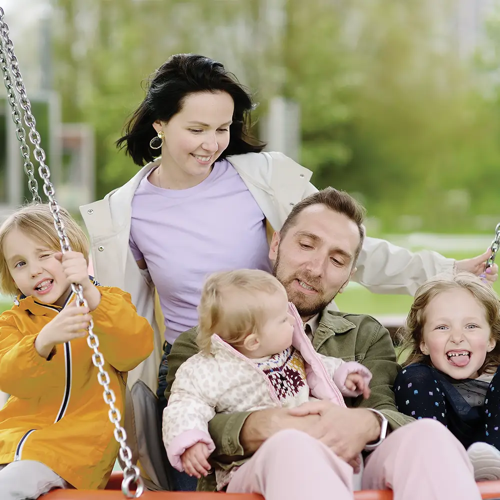 Family of 5 on a swing in the park